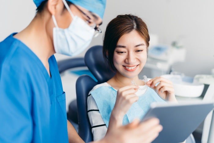 Dentist explaining Invisalign aligners teeth straightening process to a patient in Millersville, MD