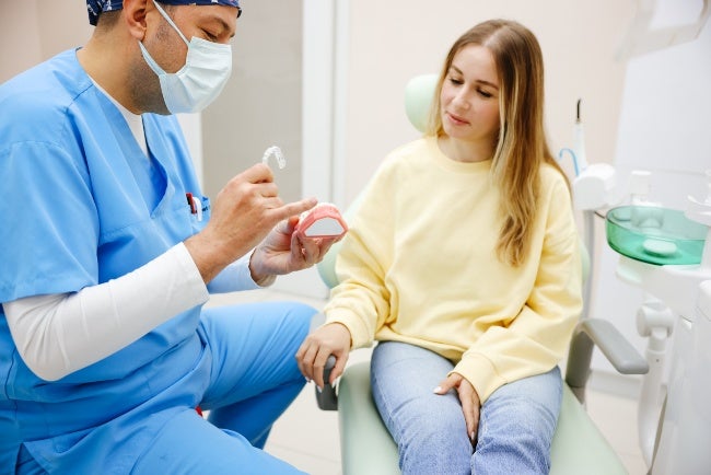 Dentist explaining Invisalign aligners teeth straightening process to a patient in Millersville, MD