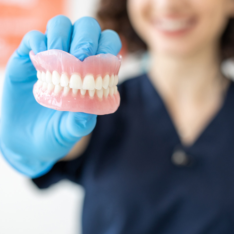 dentist holding dentures