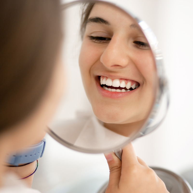 lady holding a mirror smiling