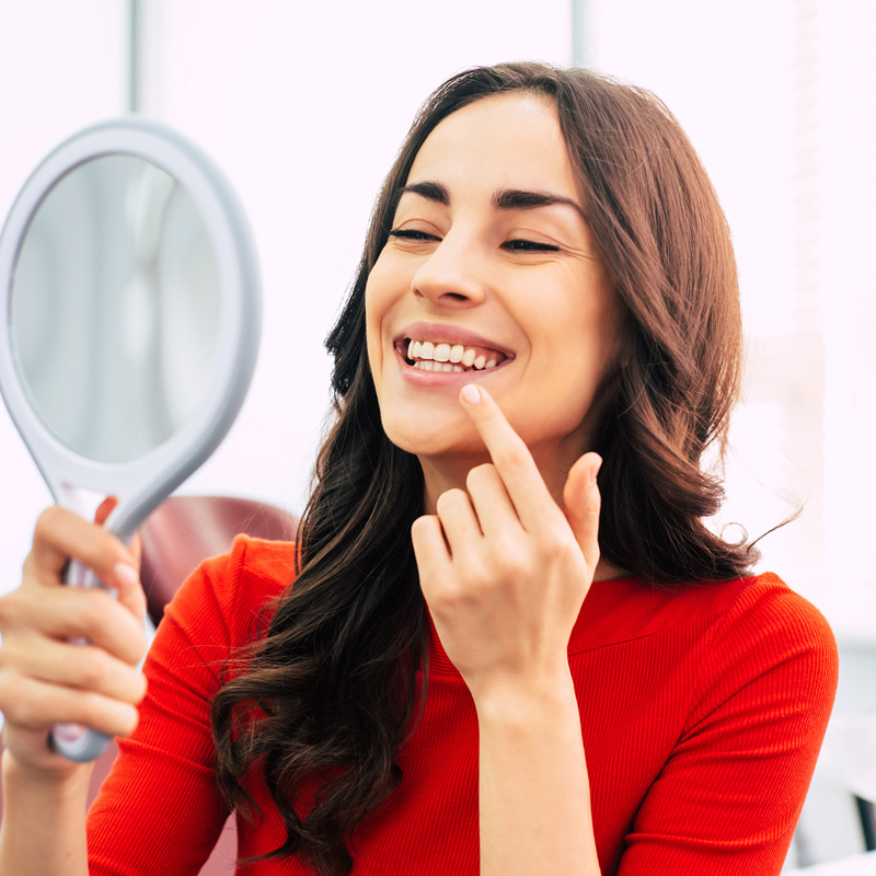 lady holding a mirror smiling