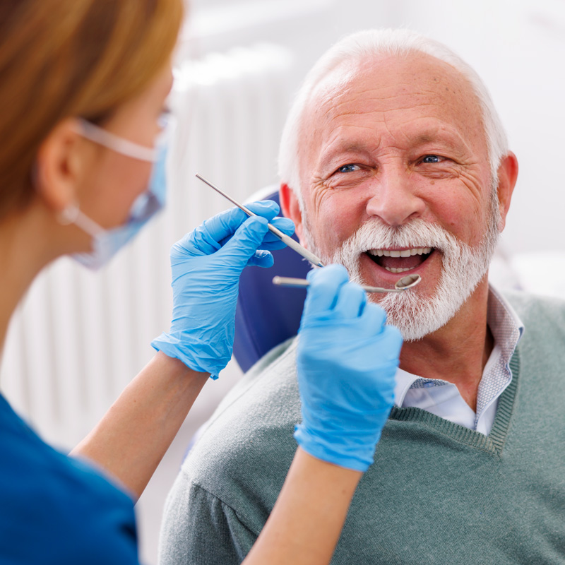 man smiling in dental chair at dentist