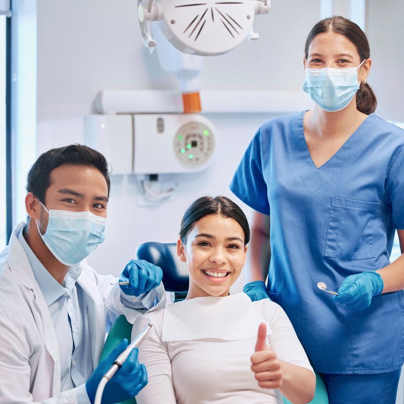 Dental team performing routine checkup with patient in clinic chair in Millersville, MD.