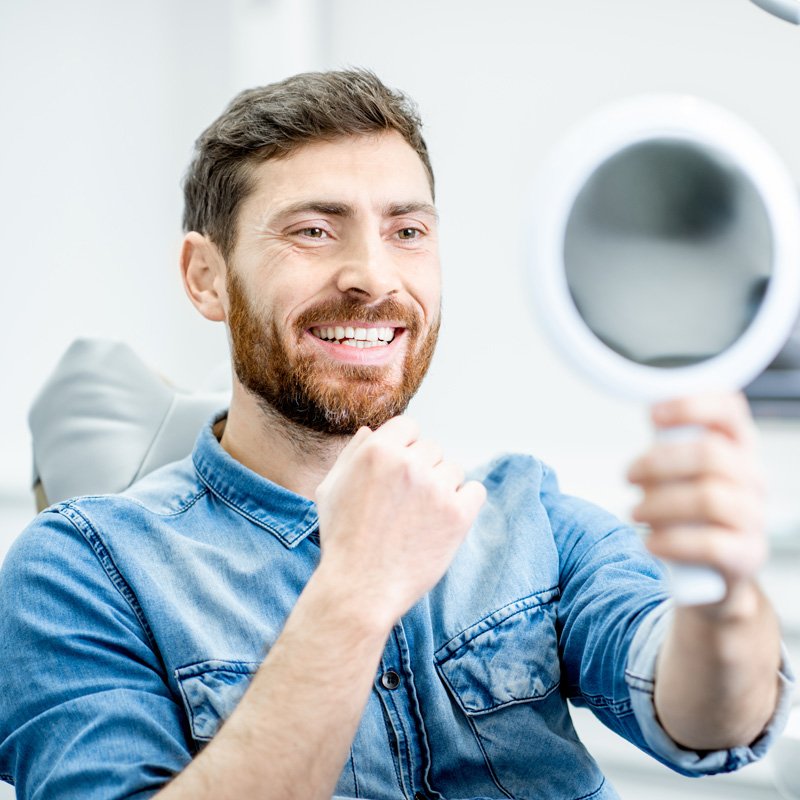 Patient checking smile after dental inlay and onlay application in Millersville, MD